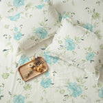 Floral bedding set with a wooden tray and dried flowers on a matching fabric background