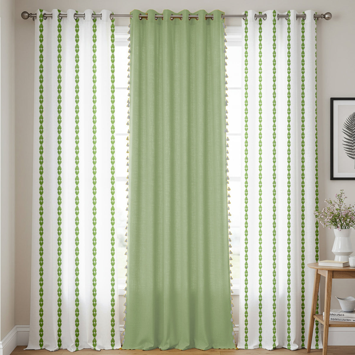 Set of three curtains with two sheer white side panels featuring vertical green leaf patterns and one solid sage green.