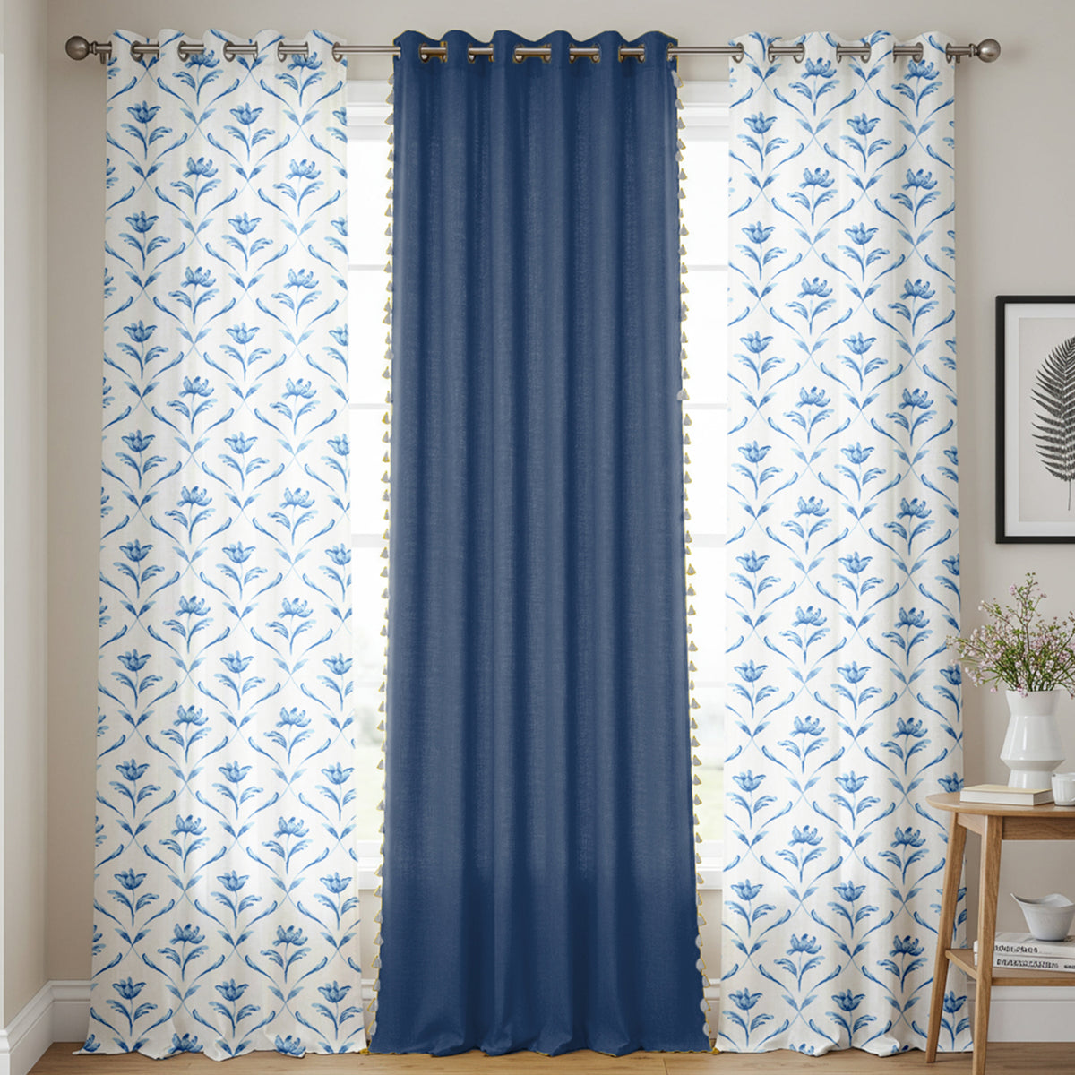 Set of three cotton curtains with two white panels featuring blue floral patterns and one solid deep blue panel in the.